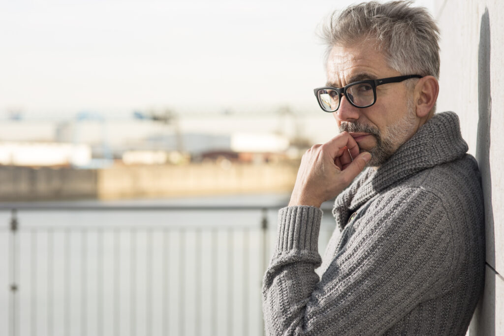 Nachdenkliche Person als Symbol für berufliche Neuorientierung bei veränderter Lebenssituation und neuen Prioritäten